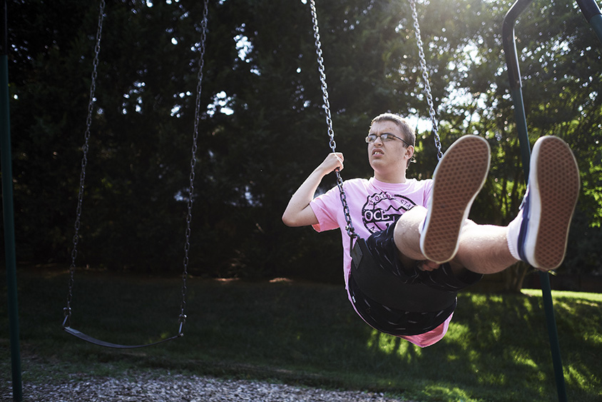 Kyle Becker, 17, rides a swing in a park near his home in Potomac, Md
